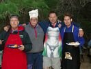 Four men, three of whom are wearing aprons